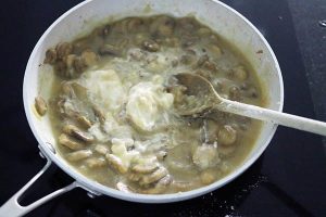 Champignonroomsaus stap 3 - roer de crème fraîche er door