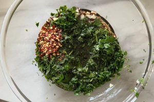Chimichurri stap 3: Voegg zout, chilivlokken, olijfolie en rode wijnazijn toe en mix alles goed door elkaar.